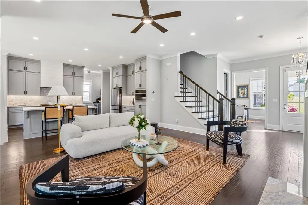 Living area featuring plenty of natural light, dark wood-type flooring, and ornamental molding