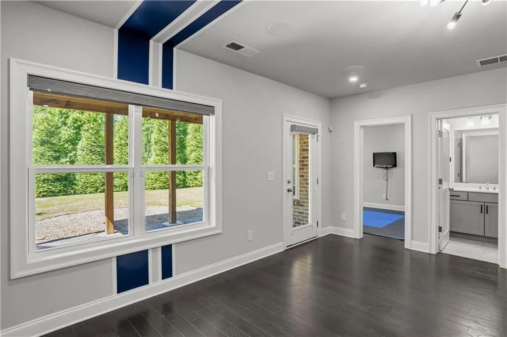 Empty room with wood finished floors, baseboards, and visible vents