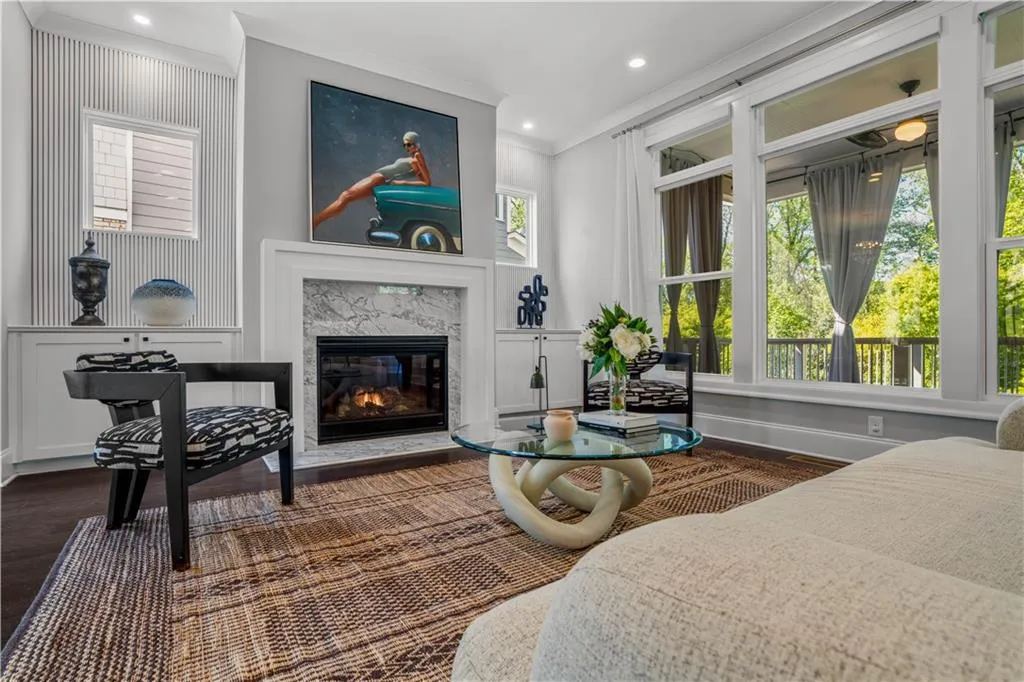 Sitting room with crown molding, a high end fireplace, dark wood finished floors, and a wealth of natural light