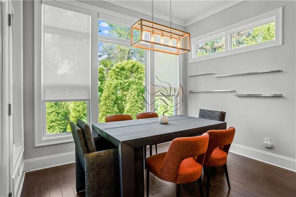 Dining room with dark wood-type flooring, baseboards, a chandelier, and crown molding