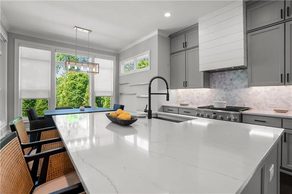 Kitchen with gray cabinets, backsplash, a sink, and ornamental molding