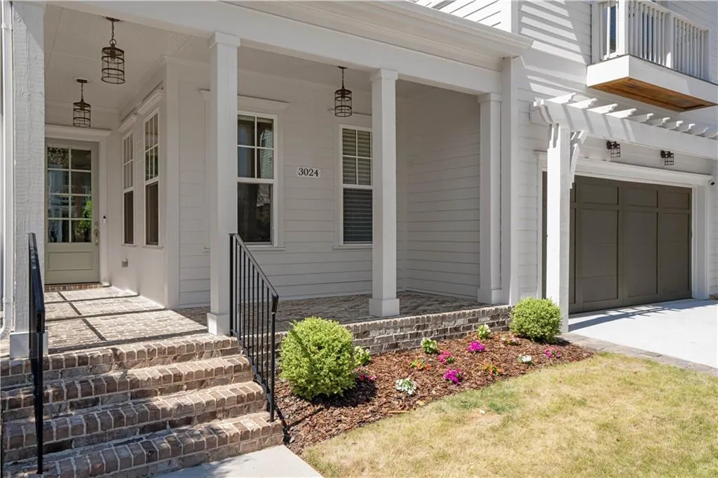 Doorway to property with an attached garage, driveway, and a porch