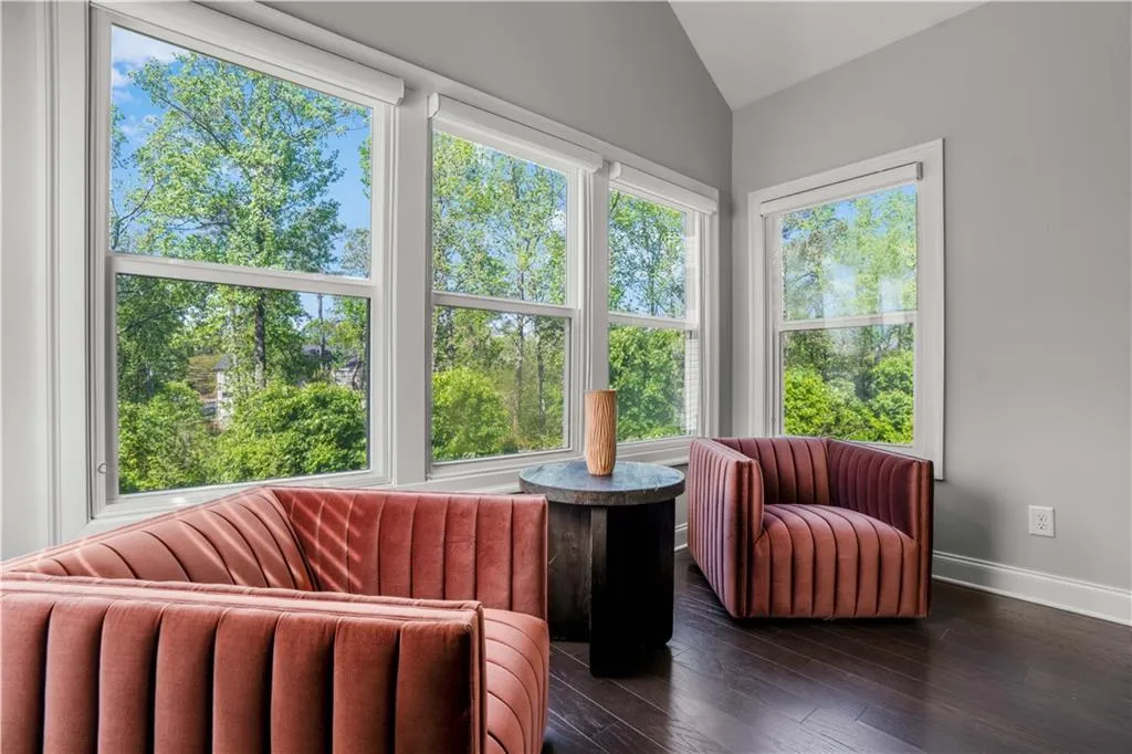 Sunroom / solarium featuring wood finished floors, baseboards, and lofted ceiling