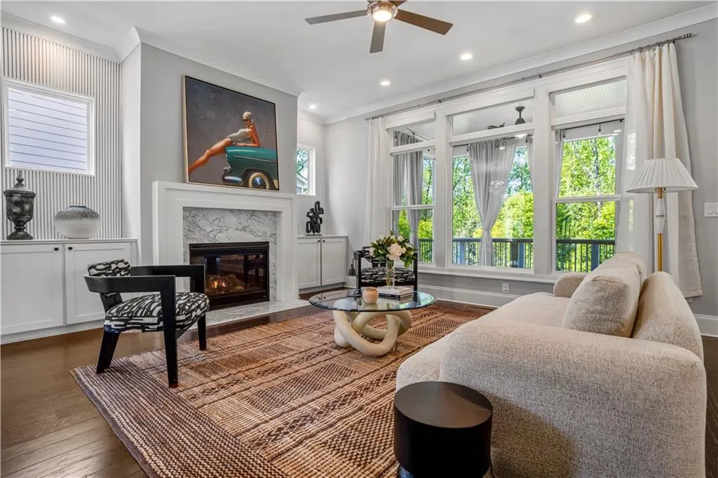 Living room featuring recessed lighting, a fireplace, a ceiling fan, crown molding, and wood finished floors