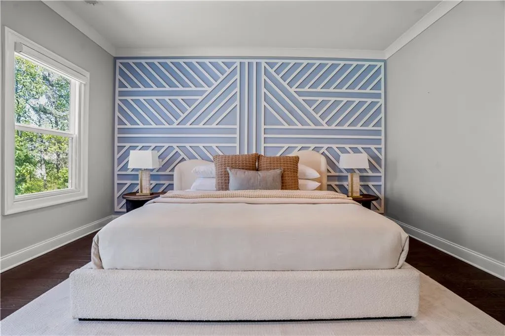 Bedroom featuring baseboards, crown molding, and wood finished floors