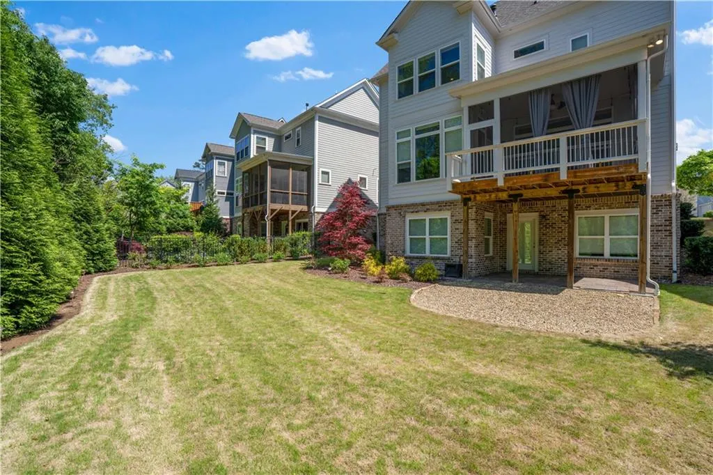 Back of property with a patio area, brick siding, central AC, a yard, and a sunroom