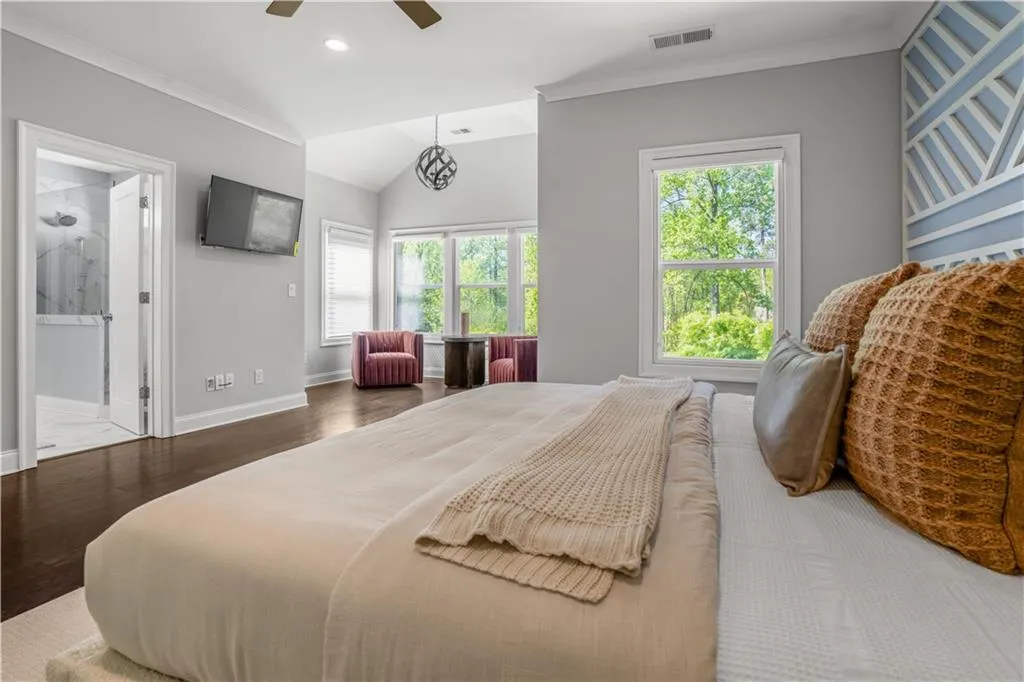 Bedroom with visible vents, multiple windows, ornamental molding, and wood finished floors