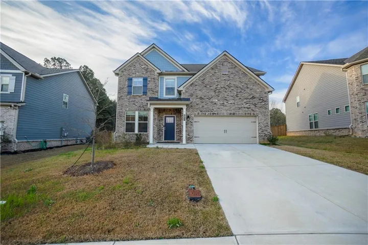 Craftsman-style house with driveway, a garage, and brick siding