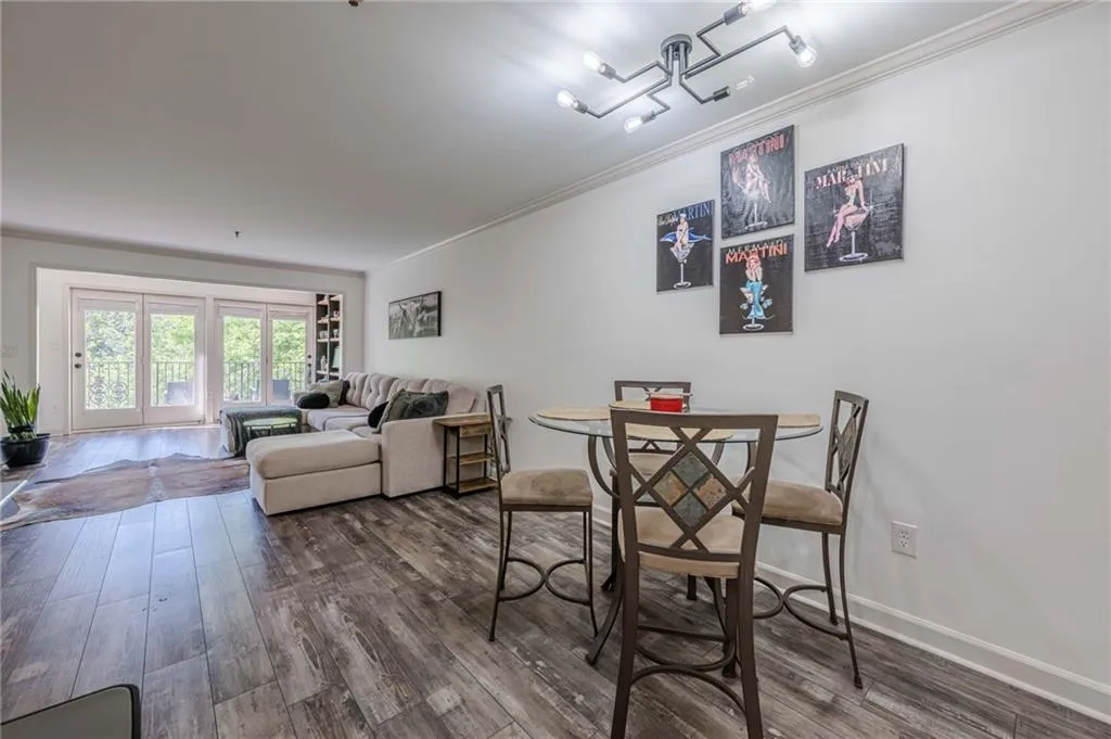 Dining space featuring ornamental molding and dark wood-style floors