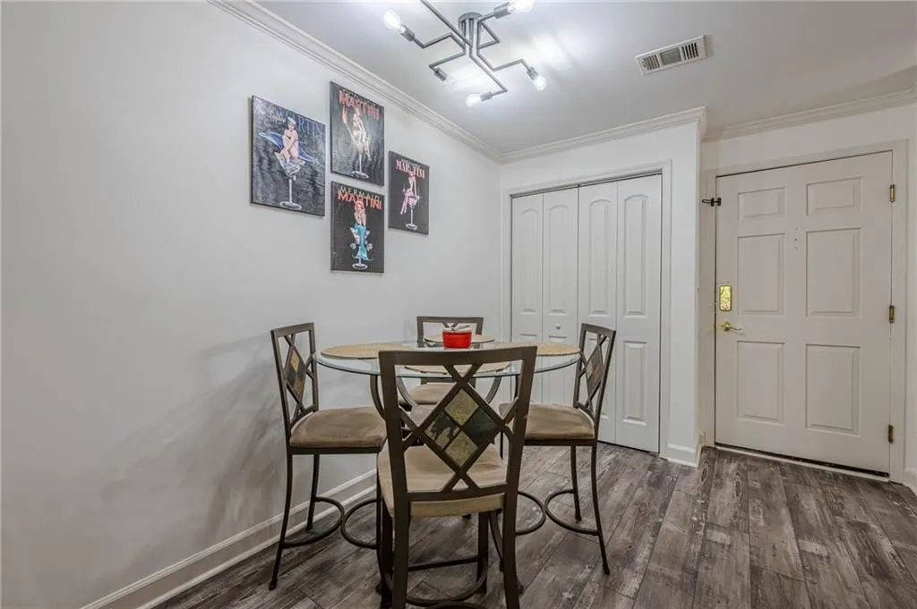 Dining area featuring ornamental molding and dark wood-style floors