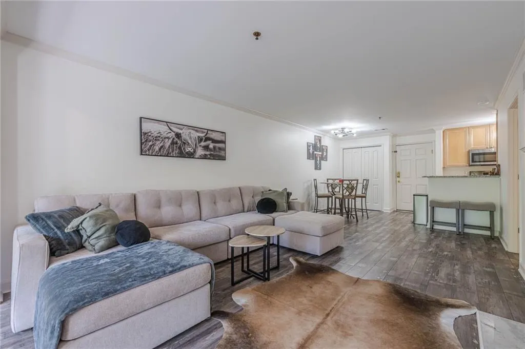 Living area with dark wood-style flooring and ornamental molding