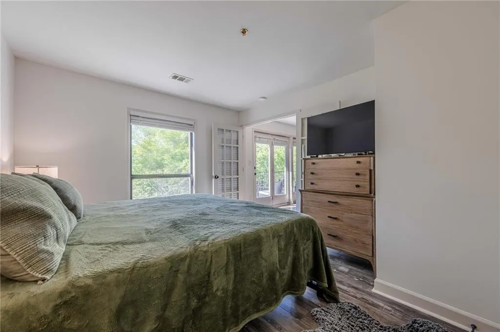Bedroom featuring dark wood-style flooring and access to exterior