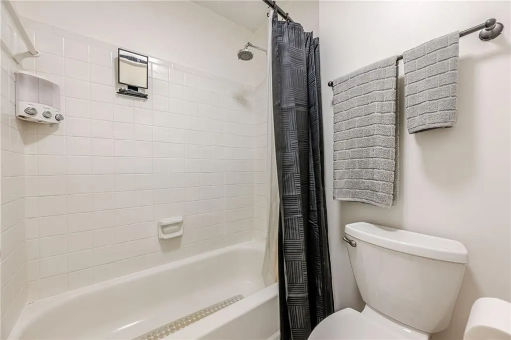 Full bath with shower / bathtub combination with curtain and toilet