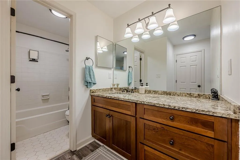 Full bathroom featuring vanity,  shower combination, and dark tile patterned floors