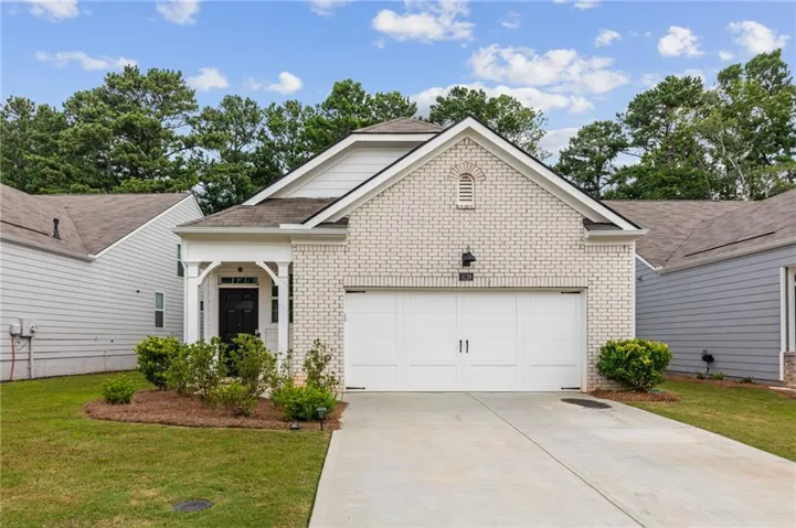 Light brick exterior with white siding accents and a covered front porch featuring decorative white columns