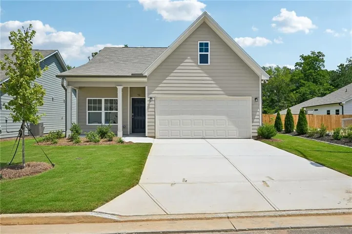 Front exterior featuring light-colored siding, an attached garage, a covered entry with columns, and a concrete driveway