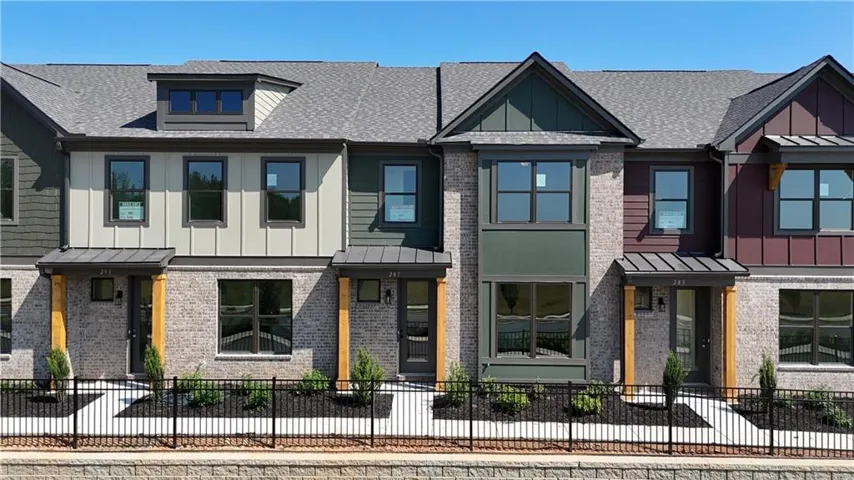 Contemporary townhome exteriors featuring varied siding, brick masonry, individual entryways, and pitched shingle roofs