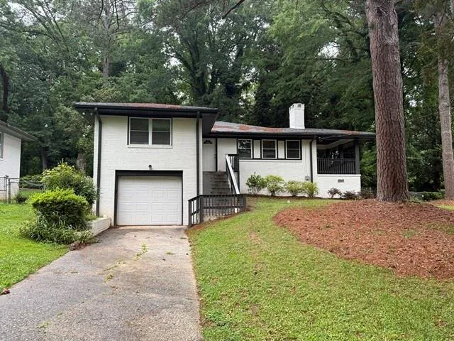White brick exterior with black trim accents and an integrated garage