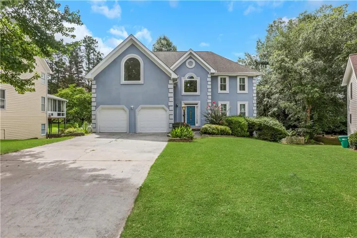 Two-story residence with a light blue exterior and white trim accents