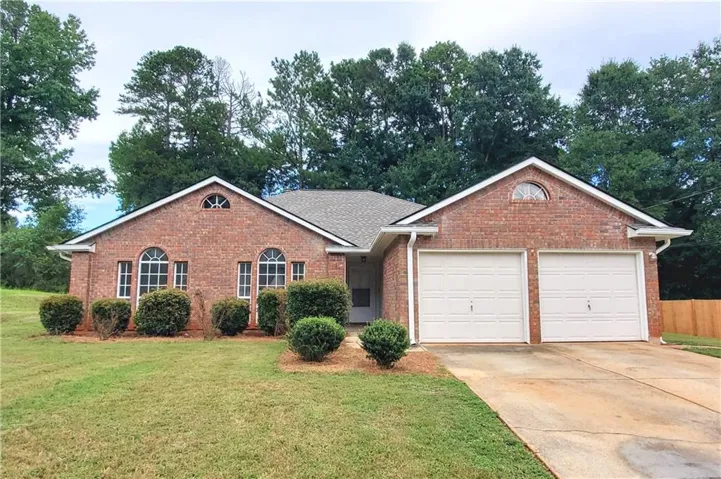 Brick exterior with a gabled roofline, arched windows, and a two-car garage