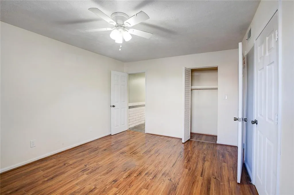 Unfurnished bedroom with a closet, wood-type flooring, and ceiling fan