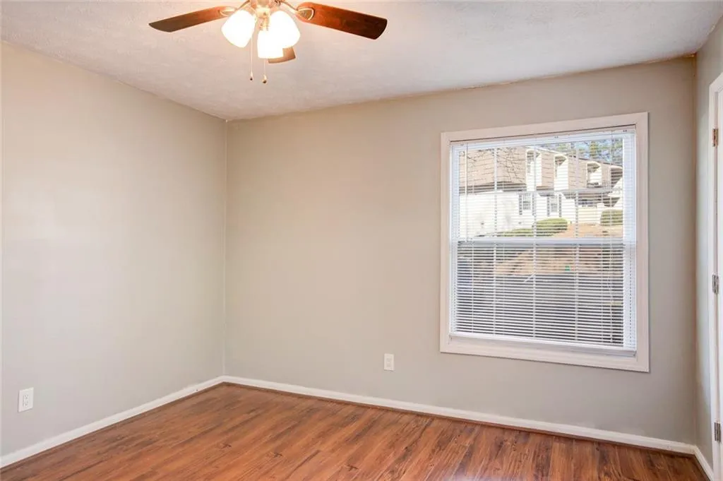 Empty room featuring wood-type flooring and ceiling fan