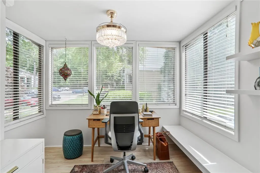 Office area featuring healthy amount of natural light, beautiful light flooring, a chandelier, and baseboards