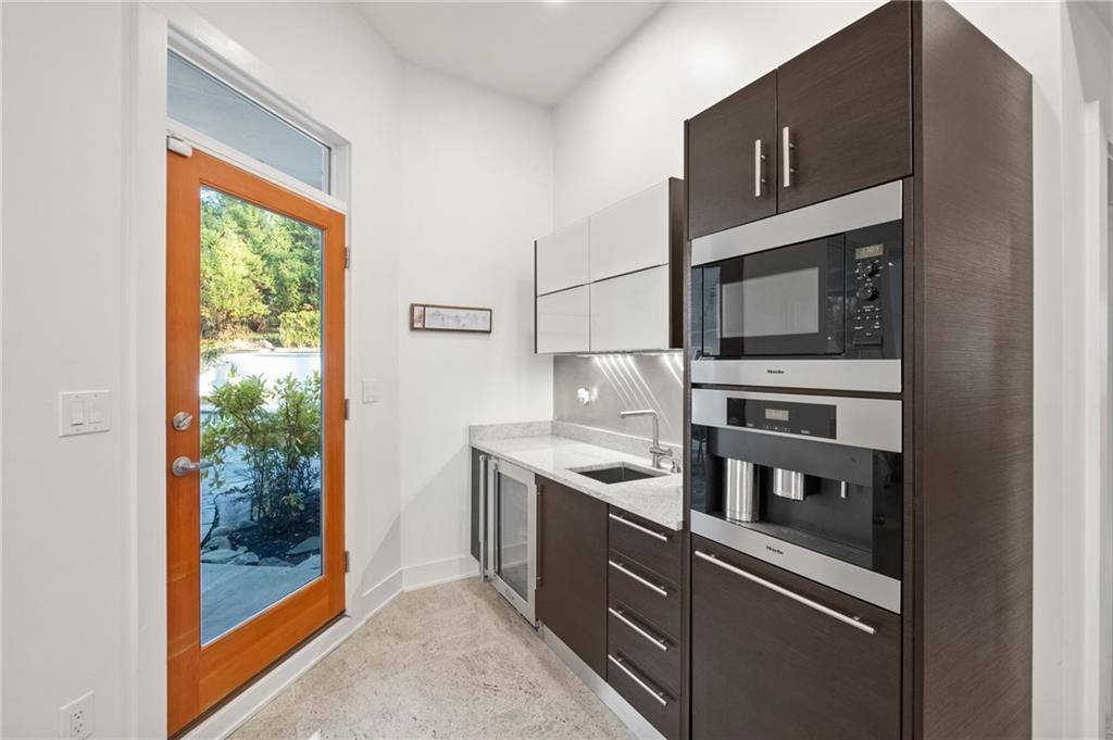 Built in Miele coffee maker, another sink, beverage refrigerator and access to patio and pool