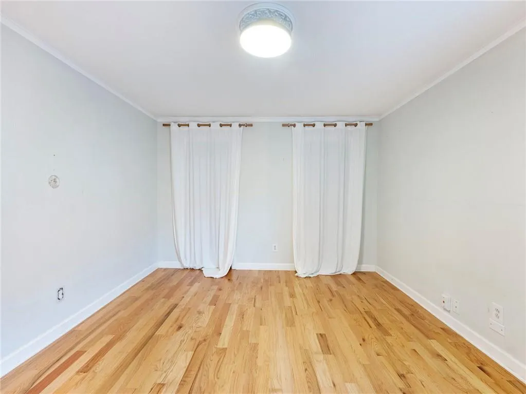 Spare room with light wood-style flooring and ornamental molding