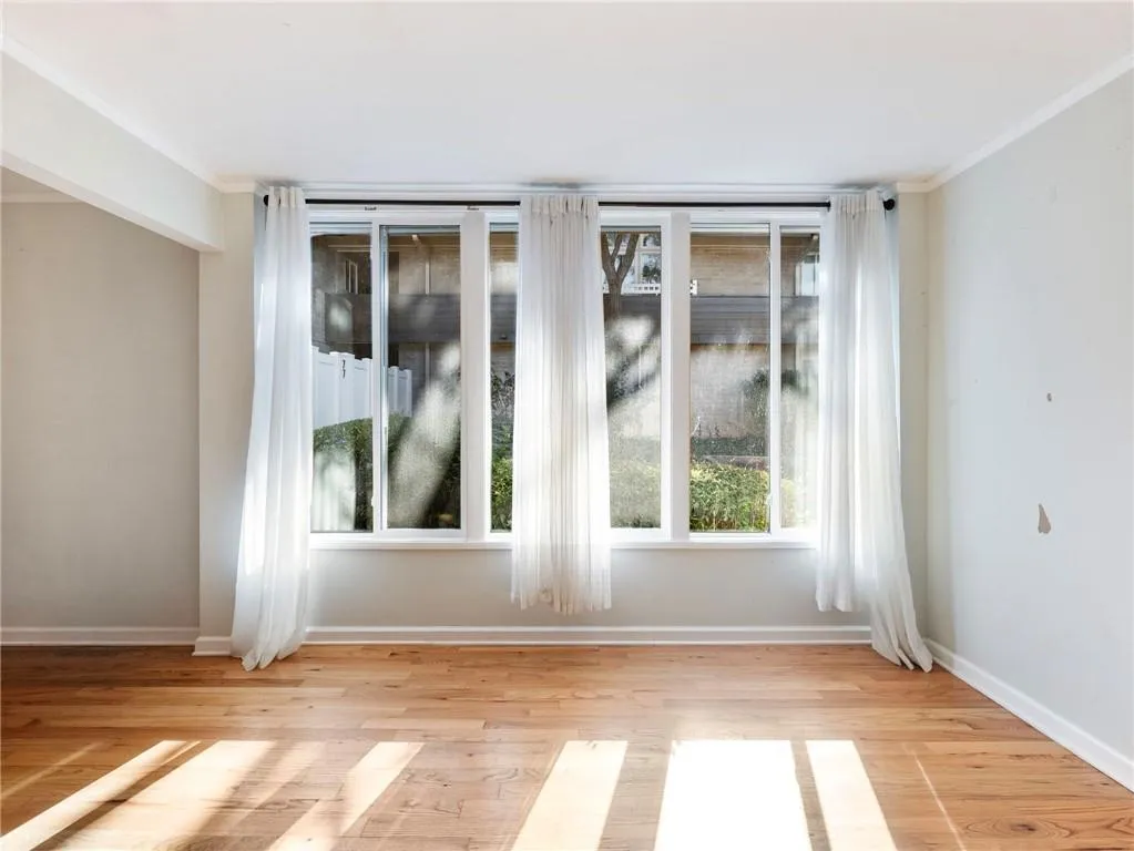Unfurnished room featuring light wood finished floors and ornamental molding