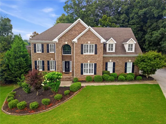Brick exterior featuring a gabled roofline and multiple dormer windows