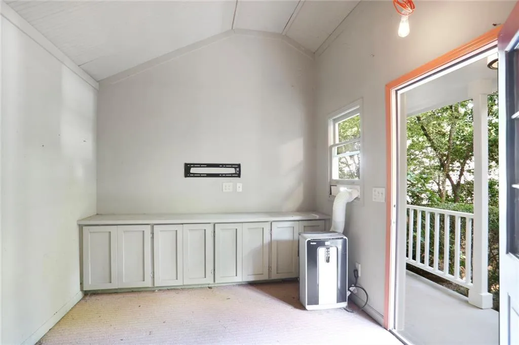 Party shed with light colored carpet and vaulted ceiling