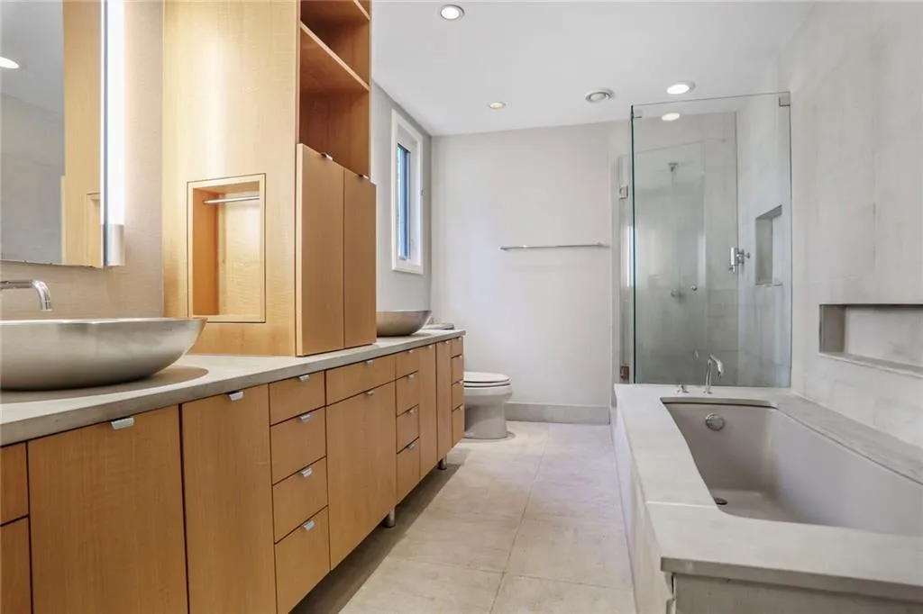 Bathroom with double vanity, a stall shower, a garden tub, tasteful backsplash, and recessed lighting