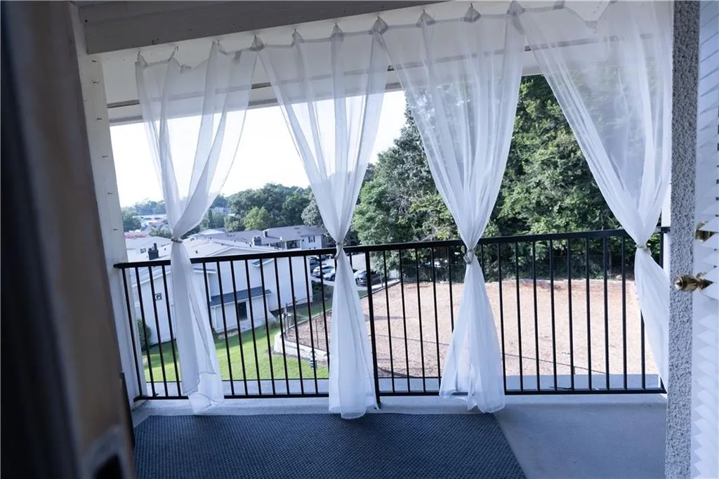Private outdoor balcony featuring a dark gray floor covering and black metal railings