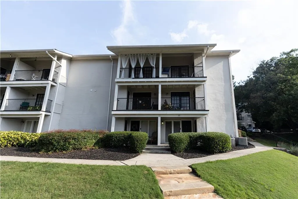Multi-story residential building with private balconies and ground-level patios