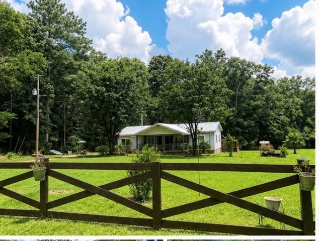 Expansive green lawn with a dark wood cross-buck fence