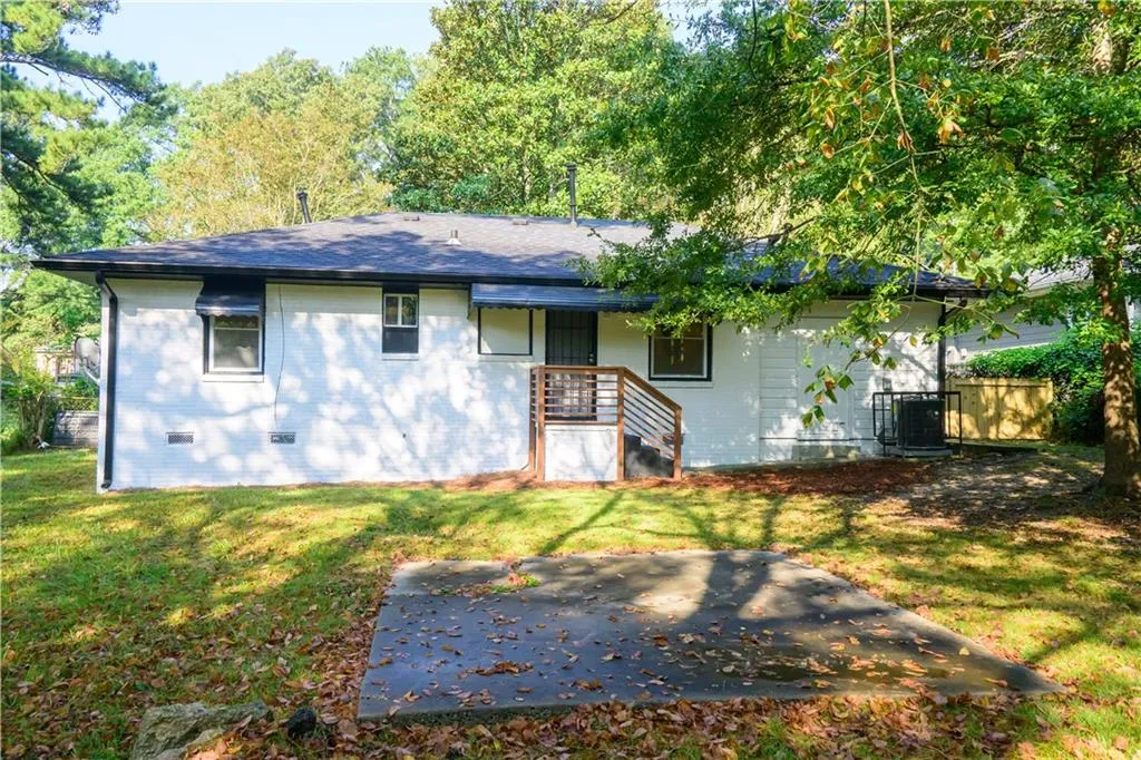 View of front of property with brick siding, roof with shingles, and crawl space
