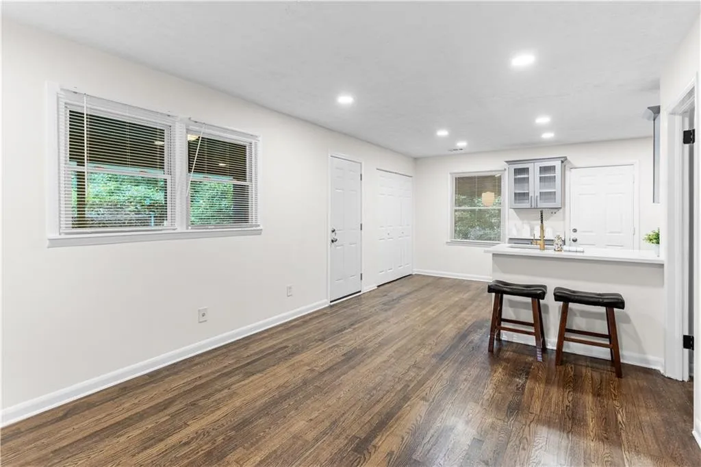 Kitchen with a peninsula, a breakfast bar area, glass insert cabinets, recessed lighting, and dark wood-style floors