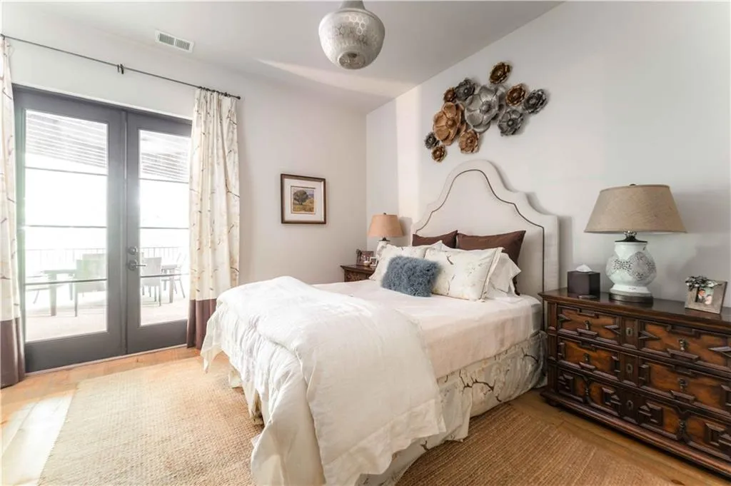 Bedroom featuring access to outside, french doors, and wood finished floors