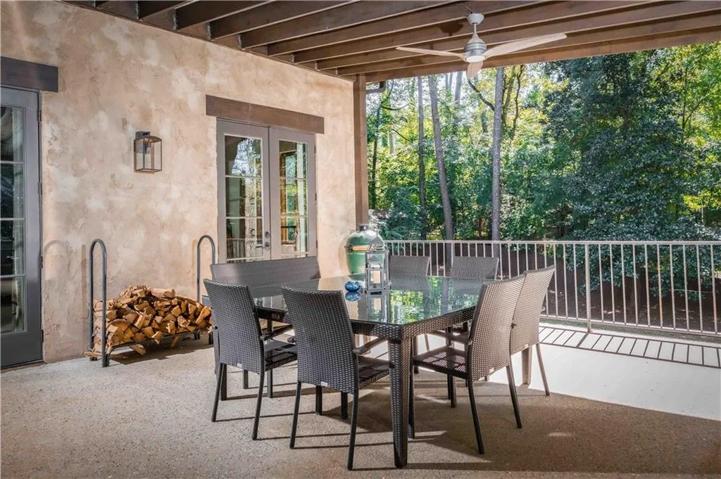 View of patio / terrace with outdoor dining area, french doors, a grill, and view of wooded area