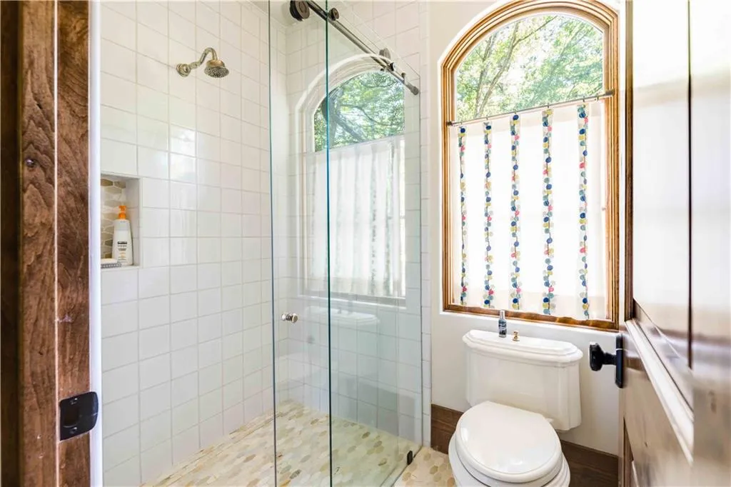 Bathroom featuring a stall shower and toilet