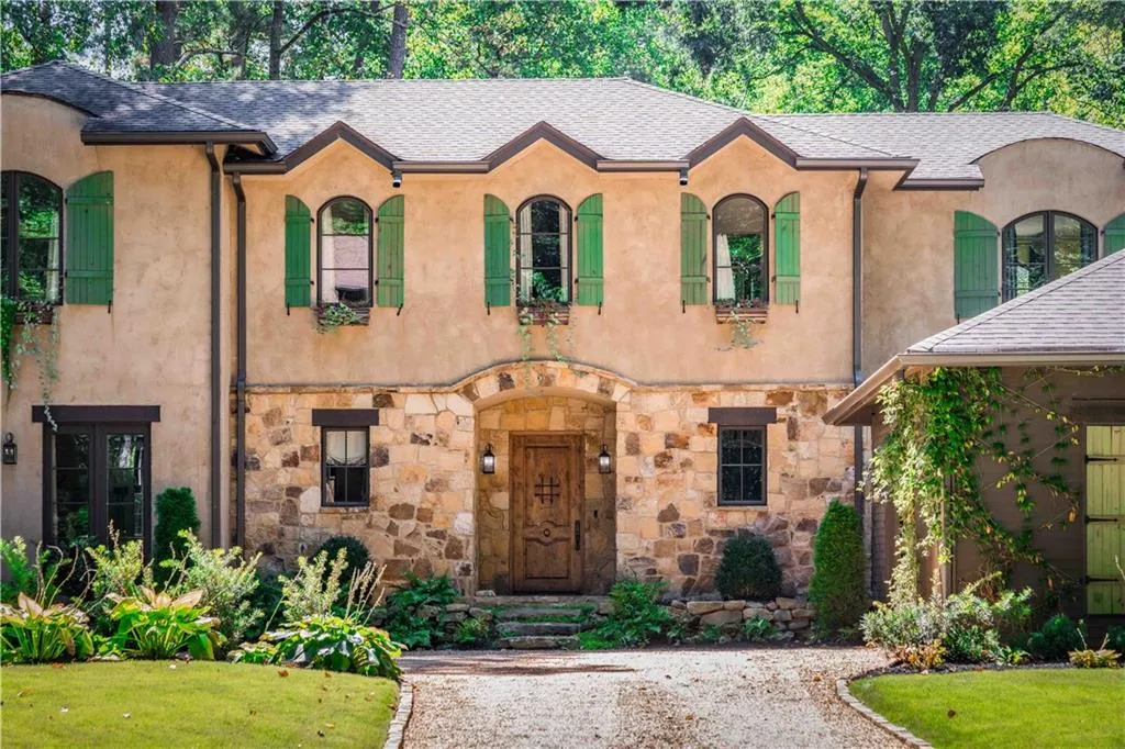 View of front of home with stone siding, stucco siding, a shingled roof, and a front yard