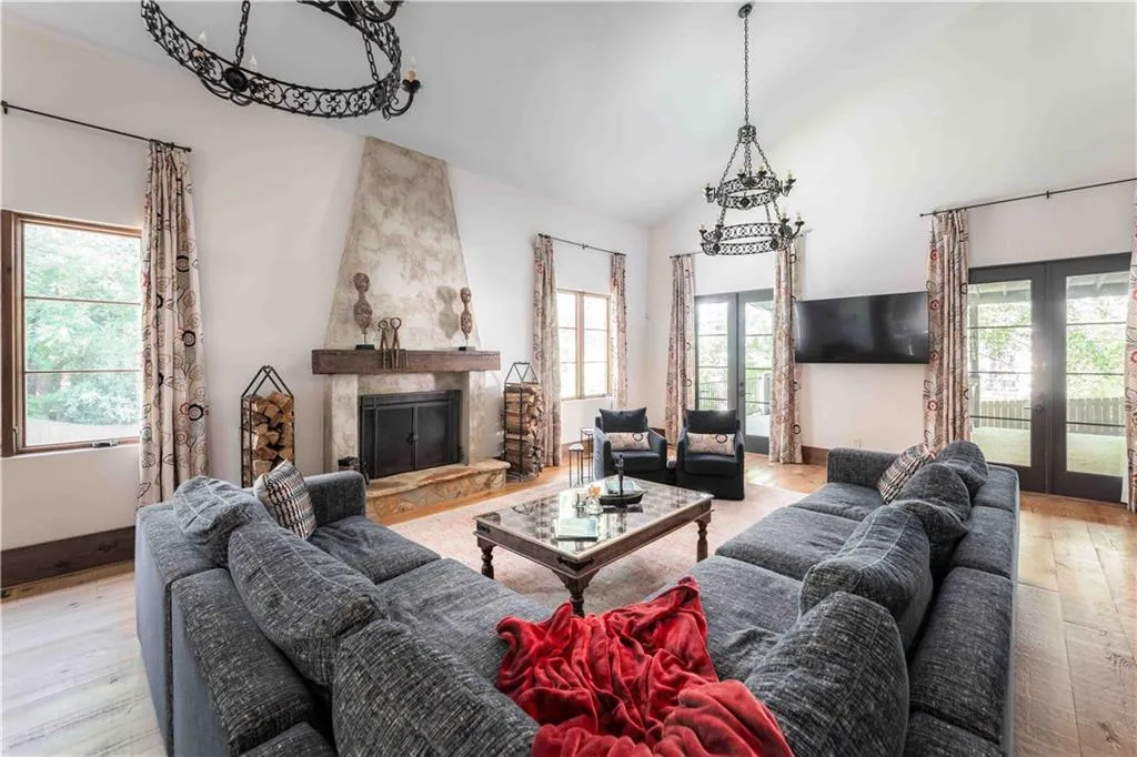 Living room featuring light wood-style floors, plenty of natural light, a fireplace, and high vaulted ceiling