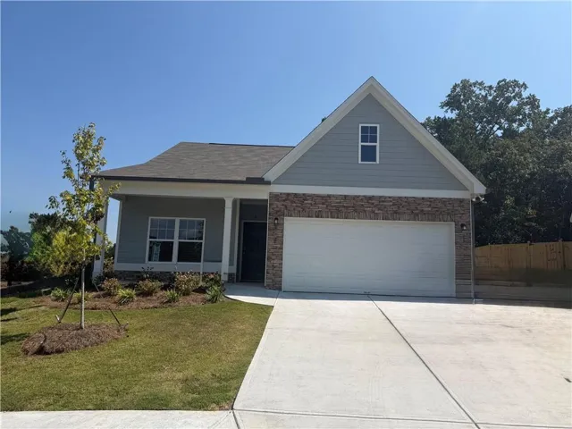 Exterior featuring a two-car garage, stone and siding facade, covered front porch, and a concrete driveway