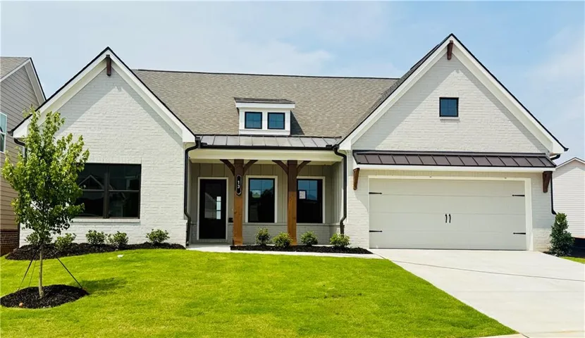 Single-story residence featuring light-colored brick facade and a dark shingle roof