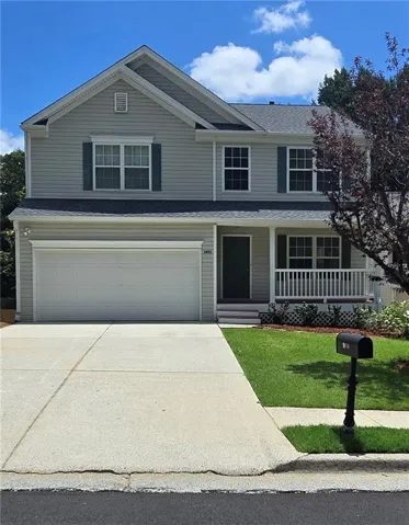 Two-story residence featuring light gray siding with dark green shutters