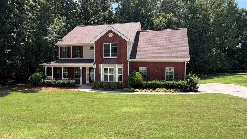Brick and siding exterior with a covered front porch, bay window, and gabled rooflines