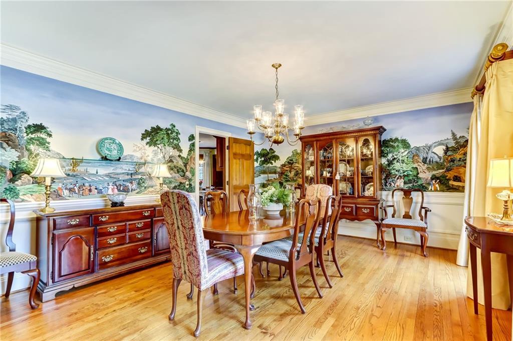 Dining area with a chandelier, ornamental molding, and light hardwood / wood-style flooring