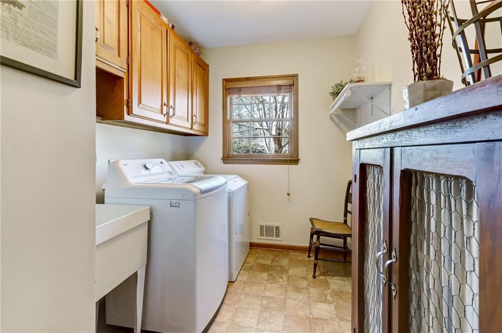 Laundry room featuring cabinets, utility closet, sink, newer washer and clothes dryer included in sale of home!