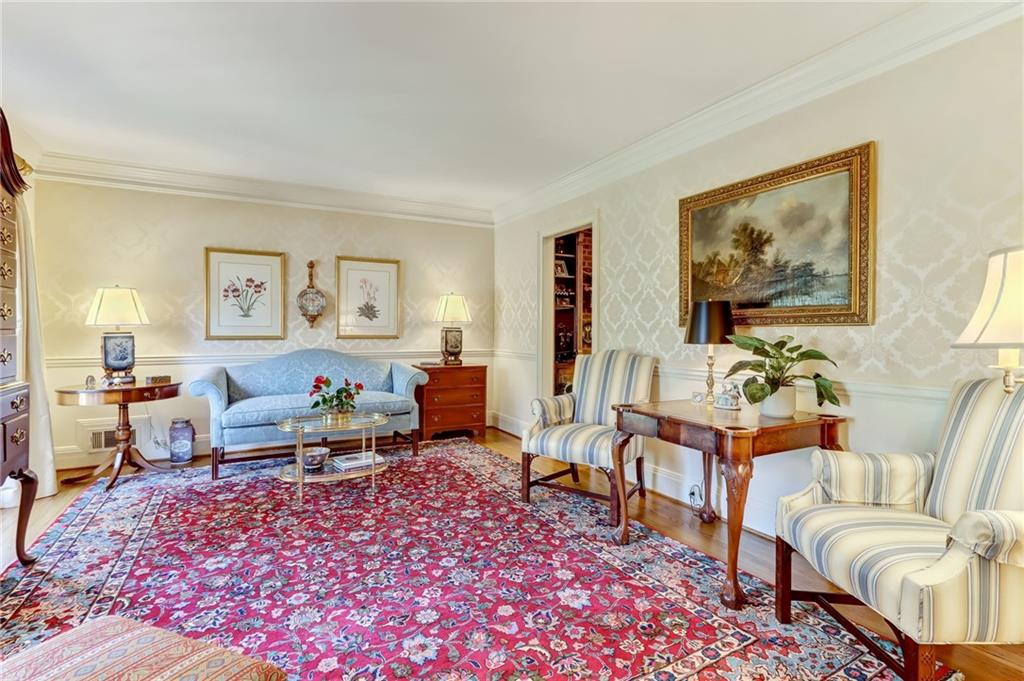 Living room with light hardwood / wood-style floors and ornamental molding